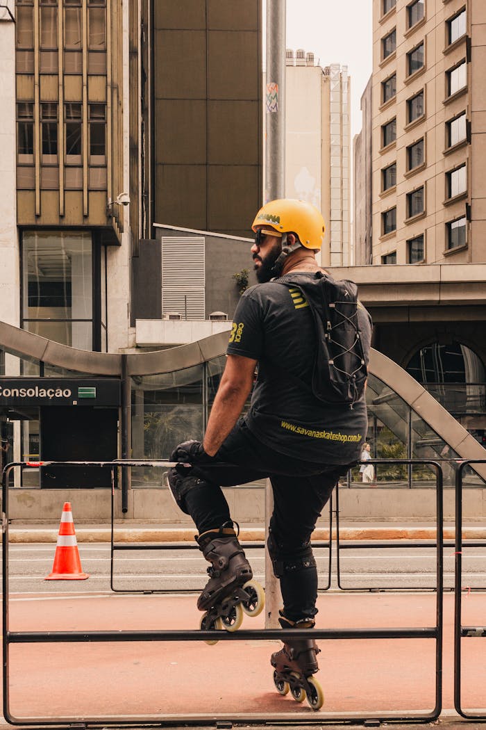services-01 Man rollerblading on city street wearing safety gear and backpack.