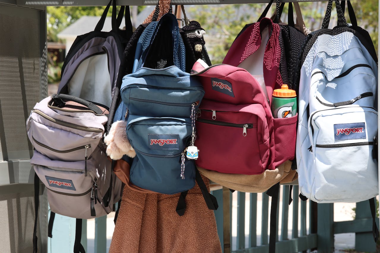 who-we-are A collection of colorful backpacks hanging outside on a sunny day. Perfect for back-to-school themes.